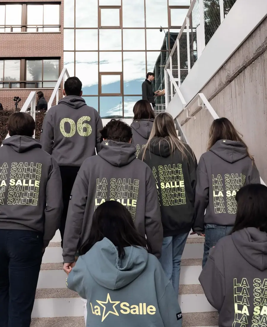 Grupo de estudiantes entrando al instituto con sudaderas personalizadas de promoción